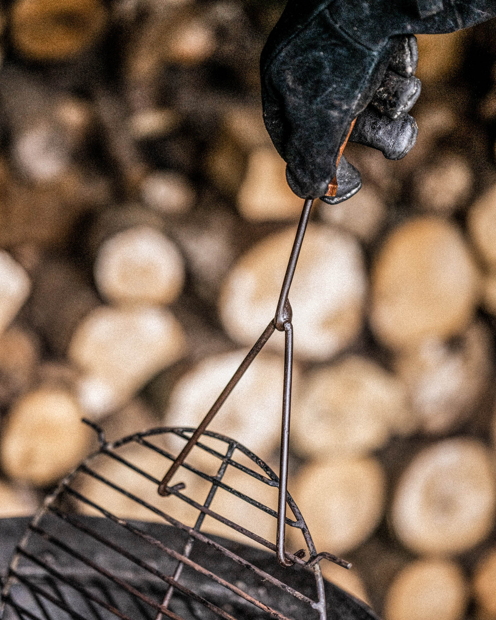 Hand wearing a kadai glove holding a a hotv grill using grill lifter