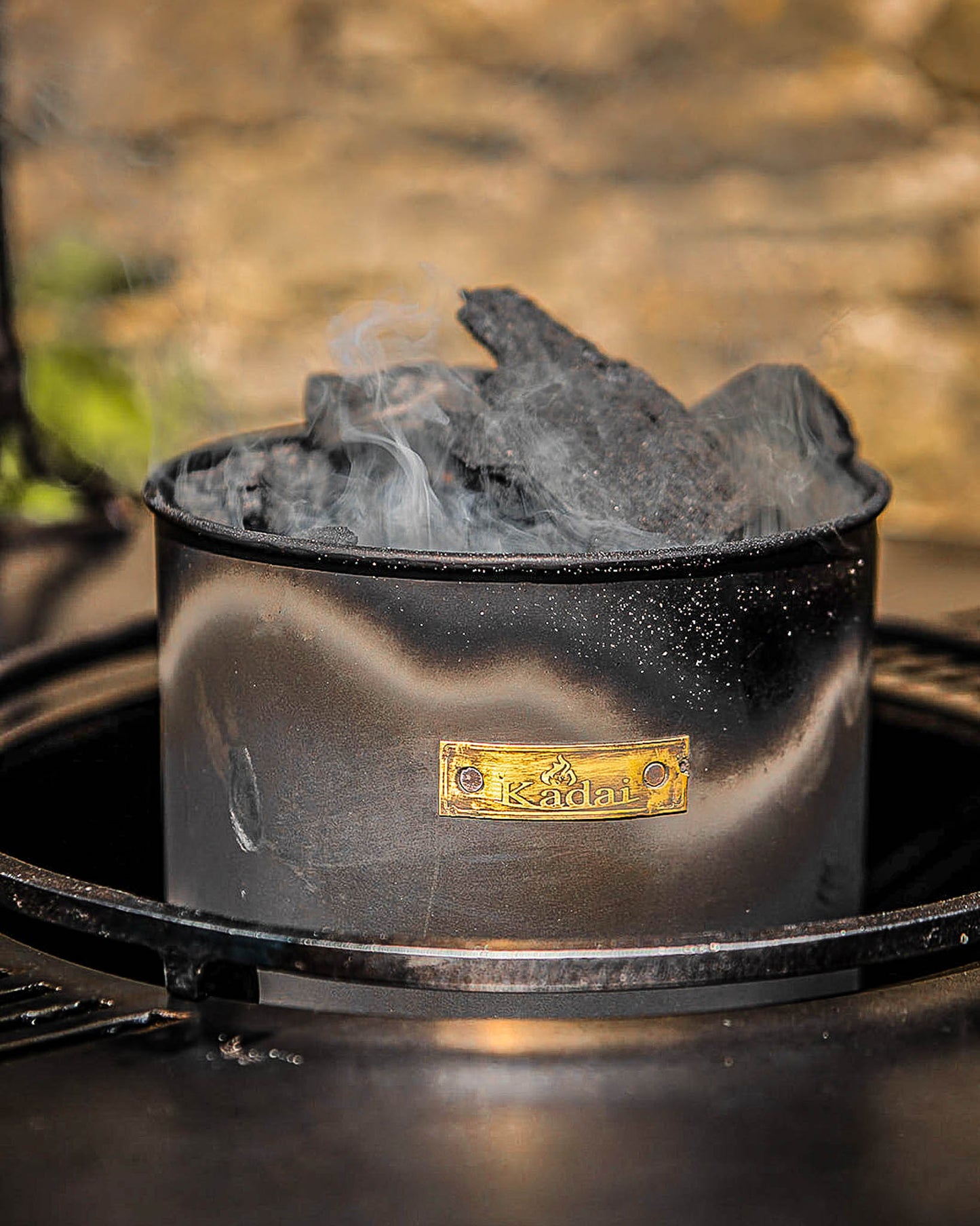 Kadai charcoal starter loaded with smoking hot coals ready to ignite an outdoor fire pit or barbecue grill