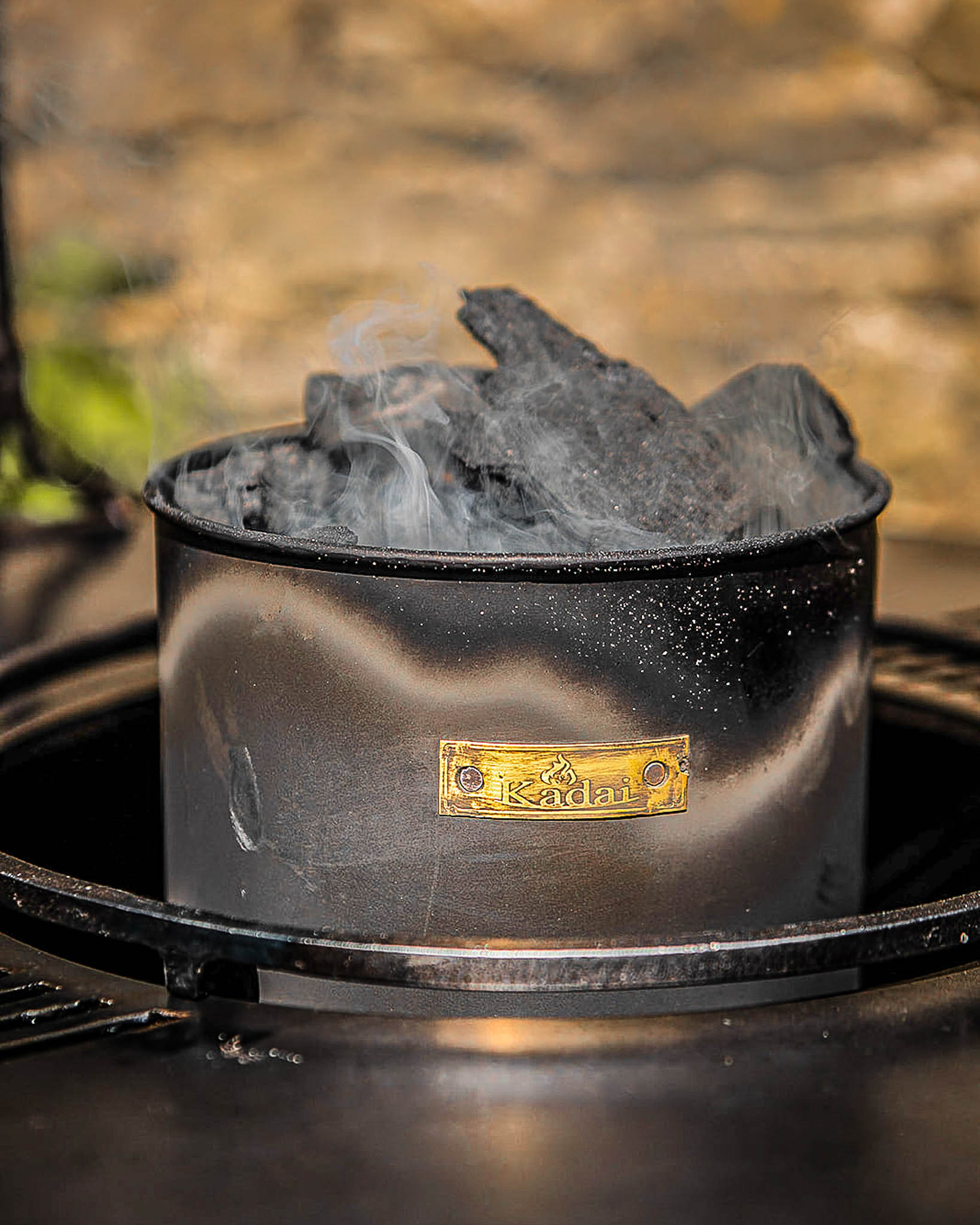 Kadai charcoal starter loaded with smoking hot coals ready to ignite an outdoor fire pit or barbecue grill