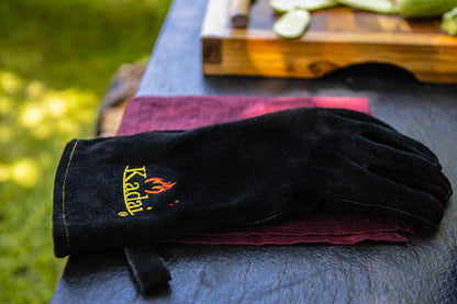 Black kadai heat-resistant glove resting on a folded cloth on an outdoor table