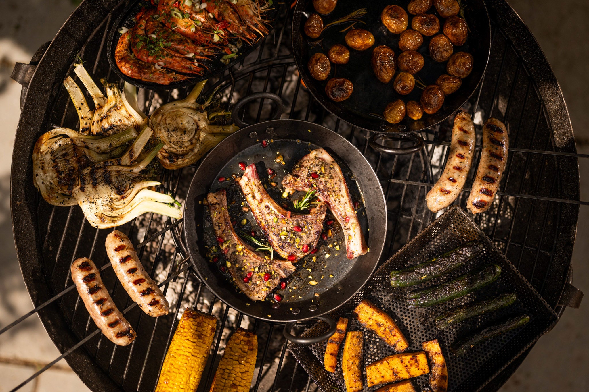 Grilled meats and vegetables on a kadai fire pit bowl.