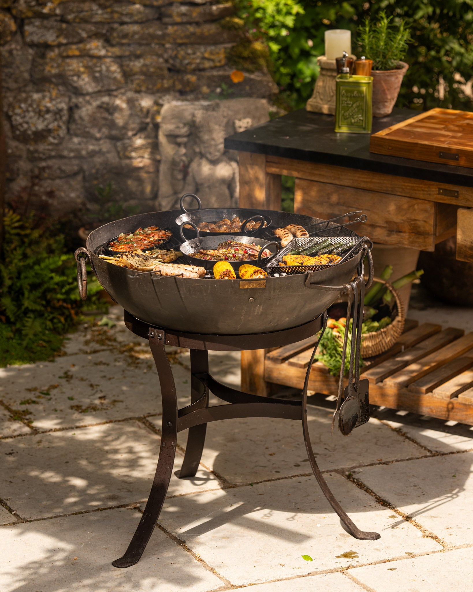 Modern BBQ fire pit on a patio with a grill full of food