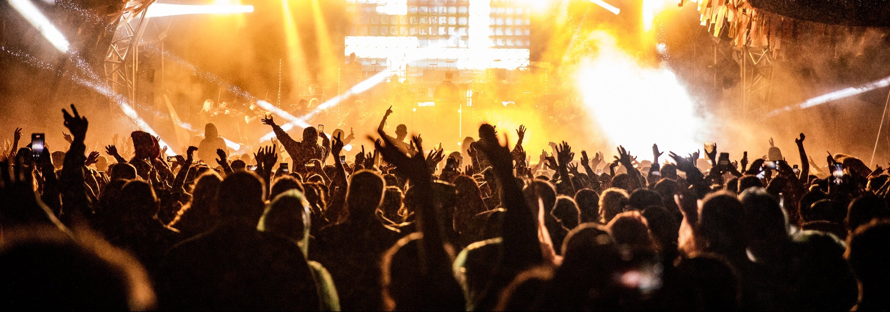 Large outdoor concert with crowd and stage lights