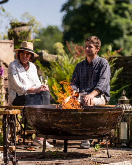 two people sitting on curved bench around kadai recycled firebowl