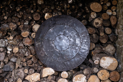 Kadai metal lid against log store