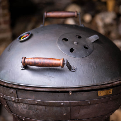 Domed charcoal grill lid featuring adjustable vent and built-in thermometer for heat control