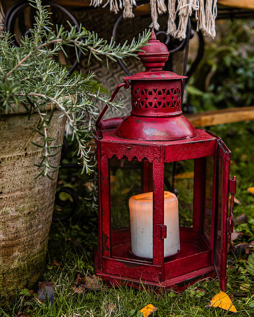 Red lantern with a candle inside on a table outdoors