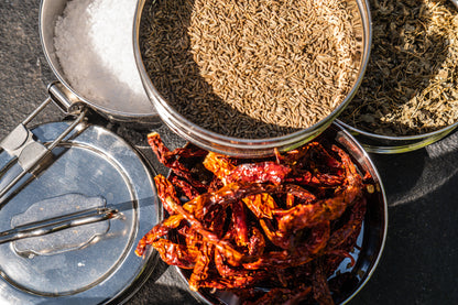 Metal tiffin tin containers with spices and chillies