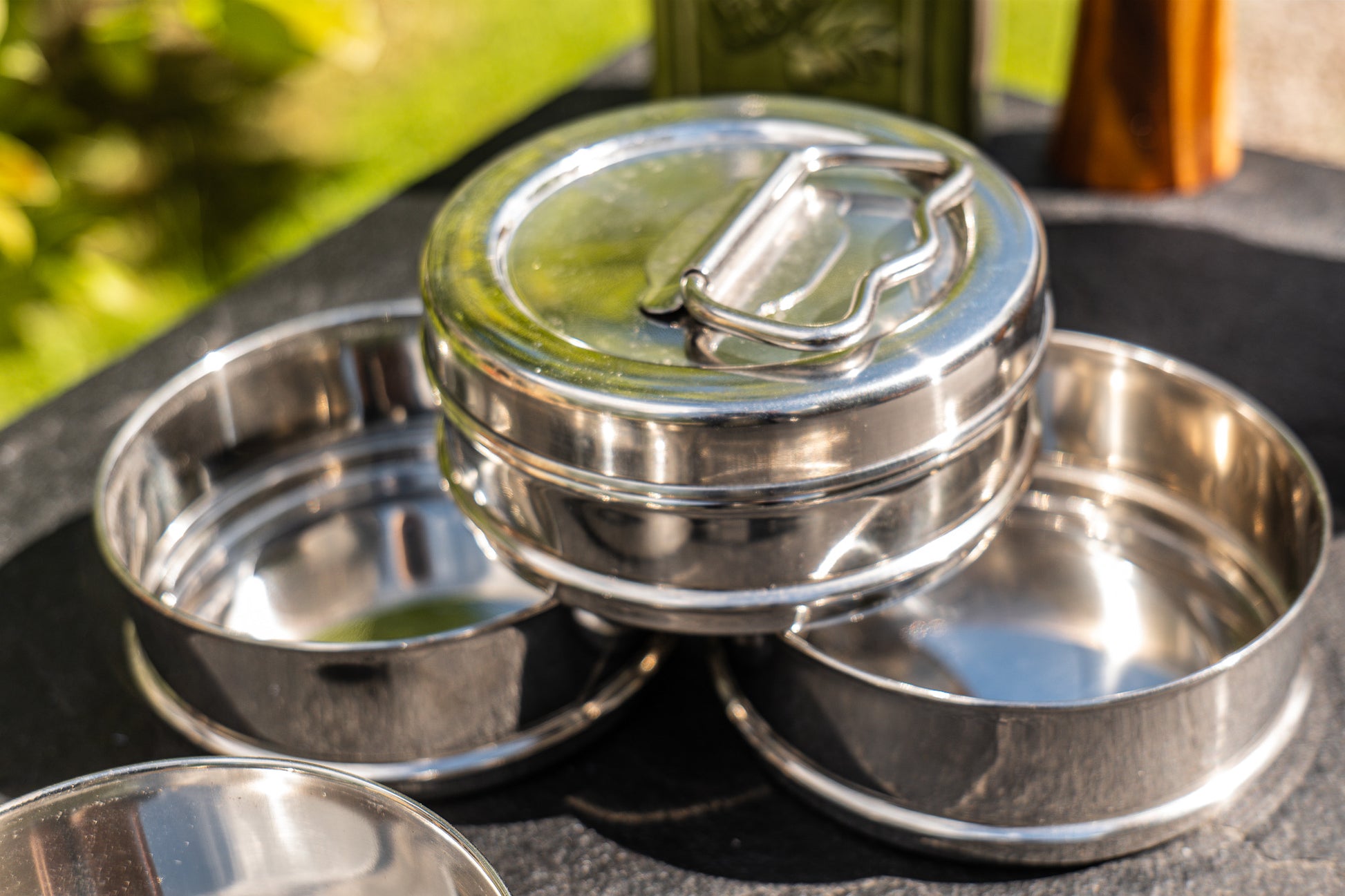 Stack of stainless steel metal tiffin tin containers on a natural background